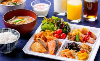 a tray filled with a variety of food , including rice , salad , and other dishes , placed on a dining table at Hotel Wing International Chitose