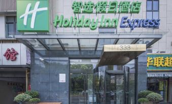 The front entrance of a restaurant is depicted, featuring a sign above it and an illuminated doorway at Holiday Inn Express Shanghai Gubei