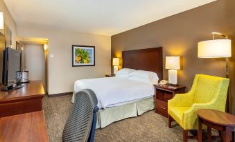 a hotel room with a large bed , yellow chair , and a painting on the wall at Wyndham San Diego Bayside