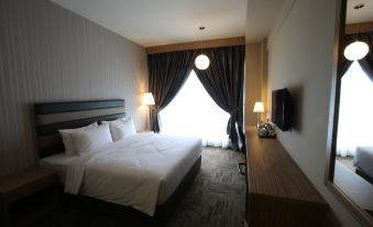 a large bed with white linens is in a room with black curtains and a television at Sem9 Senai "Formerly Known As Perth Hotel"