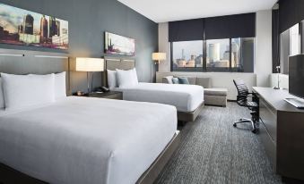 a modern hotel room with two beds , white bedding , and a view of the city through large windows at Hyatt House Jersey City