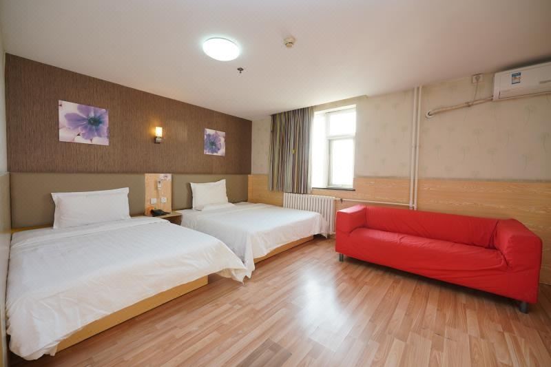 The bedroom is empty and features two beds and a large window on the side at 7 Days Inn (Beijing Temple of Heaven Dongmen Metro Station)
