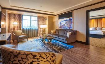 a modern living room with wooden flooring , large windows , and comfortable seating arrangements , including a blue rug with gold accents at Mount Airy Casino Resort - Adults Only