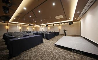 A spacious room is set up with rows of tables for an event or conference at Layers The Luxurious Hotel