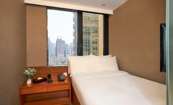 This hotel offers a bedroom with two beds and large windows that provide a nighttime view of the city at J Link Hotel
