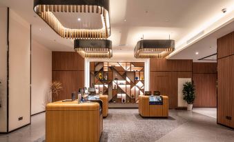 The modern lobby features an intriguing center ceiling and wood paneling at UrCove by HYATT Shanghai Jing'an