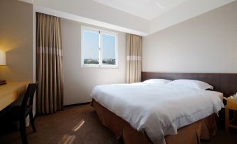 The hotel features double beds with large windows and white bedspreads in the bedrooms at City Suites (Taoyuan Gateway)