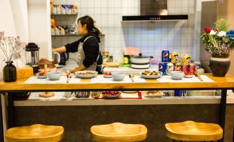 a kitchen counter with various food items and a woman in the background preparing food at yhz