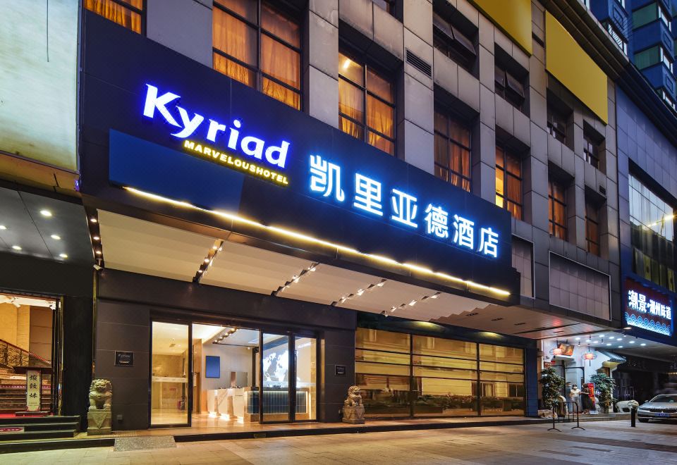 The hotel's front entrance is illuminated at night, displaying a welcoming sign above it at Kyriad Hotel (Guangzhou Railway Station Xiaobei Subway Station)