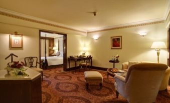 a hotel room with a bed , chairs , and a couch , along with other furniture and decorations at Pearl Continental Hotel, Lahore