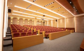 The venue includes a spacious auditorium with rows of red seats at the front, an unoccupied conference room featuring a long table and chairs, and a compact reception area with a desk and a few chairs at Landmark Vientiane Life Center