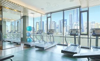 The gym features large windows that offer a view of the city, as well as an indoor exercise area at Hotel Indigo Shanghai on The Bund