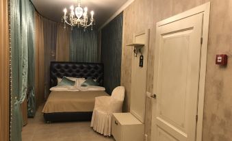 a bedroom with a large bed , chandelier , and a chair , all in a modern style at Vernisage