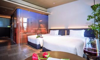 a spacious bedroom with two double beds and a large table in the center at Grade Hotel Shenzhen sea world