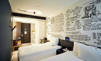 The bedroom features double beds and a decorative wall decal on the white-painted wooden wall at CitiGO Hotel Beijing Tian'anmen Square