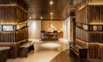 a modern office space with wooden walls , a reception area , and a desk , illuminated by overhead lights at Cochin Zen Hotel