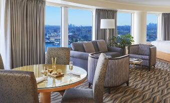 a hotel room with a dining table , couch , chairs , and a view of the city at Pan Pacific Vancouver