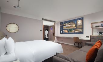The room is equipped with a double bed and a large screen TV mounted on the wall above it at Peony Hotel