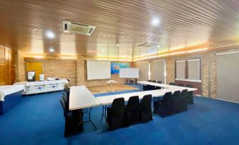 a conference room with a long table , chairs , and a projector screen set up for an event at Carnarvon Motel