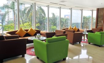 a modern living room with various seating options , including couches , chairs , and a coffee table at ASTON Pluit Hotel & Residence