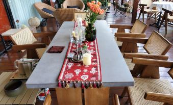 a wooden dining table with a red and white runner , surrounded by chairs on a patio at Swan Hotel