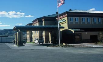 a large , modern hotel building with a flag on top and a parking lot in front at Holiday Inn Rock Springs