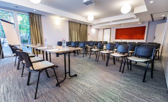 a conference room with rows of chairs arranged in a semicircle , and a podium at the front at Utopia Hotel - Art & Nature Hotel