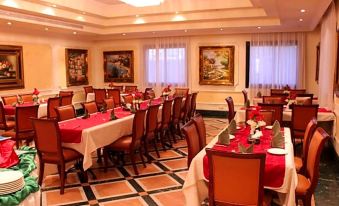 a large dining room with multiple tables and chairs arranged for a group of people at Golden Hotel