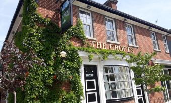 "a brick building with a sign that reads "" the crofts "" on it , surrounded by greenery" at Crofts Hotel