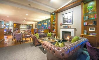 a cozy living room with a leather couch and a fireplace , creating a warm and inviting atmosphere at Cork International Hotel