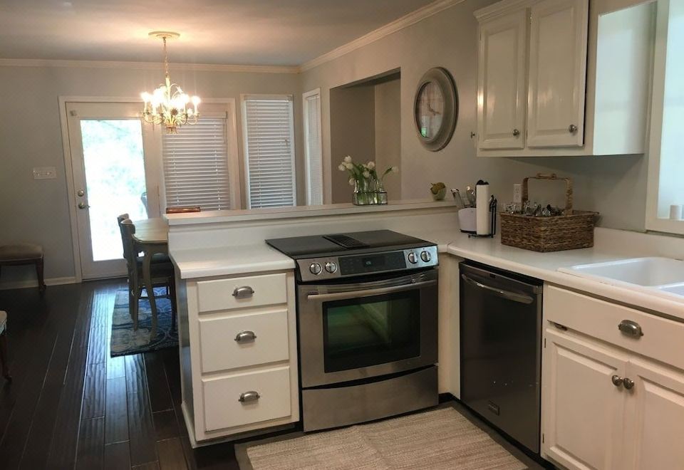 a kitchen with white cabinets , a stove top oven , and a sink in the corner at The Waterford