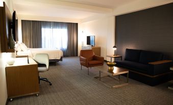 a modern hotel room with a bed , couch , chairs , and coffee table , all arranged in a spacious and clean environment at Courtyard Philadelphia Springfield