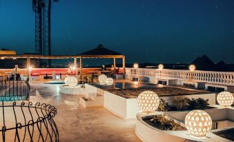 a rooftop patio with a variety of seating options , including couches , chairs , and a dining table at Desert Moon