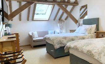 a room with two beds , one on the left side and the other on the right side at South Park Farm Barn