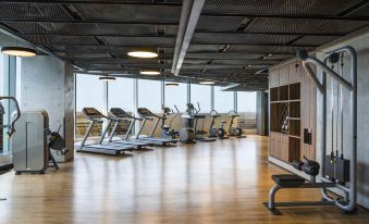 a modern gym with multiple treadmills and exercise equipment , providing a comfortable space for people to exercise at Swissôtel Jakarta Pik Avenue