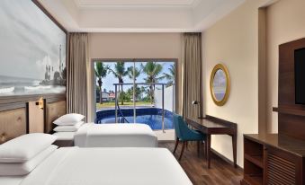 a hotel room with two beds , a desk , and a view of a pool outside the window at Sheraton Kosgoda Turtle Beach Resort