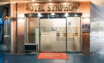 "the entrance to a hotel with a red carpet and a glass door that says "" hotel symphony .""." at Symphony Hotel