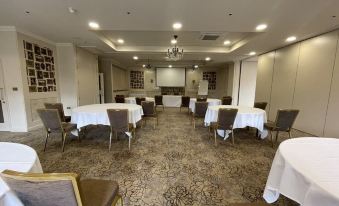 a large conference room with multiple round tables and chairs arranged for a meeting or event at Cbh Park Farm Hotel