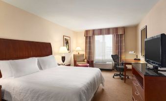 a hotel room with a large bed , a desk , and a window , all neatly arranged at Hilton Garden Inn Bartlesville