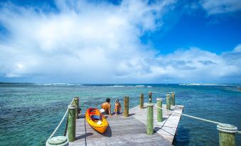 a man is sitting in a kayak on a wooden dock next to the ocean at Sinalei Reef Resort & Spa