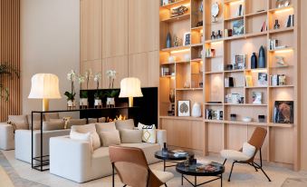 a modern living room with a fireplace , white couches , and wooden shelves filled with various items at Riviera Marriott Hotel la Porte de Monaco