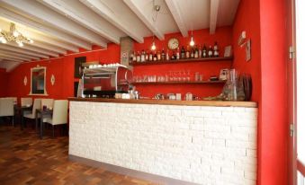 a red and white kitchen with a brick countertop , wooden cabinets , and various cooking utensils at Art Hotel