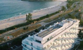a large white building with a balcony is situated on the beach , overlooking the ocean at CDesign Hotel