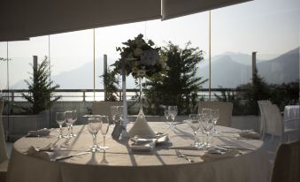 a table is set with wine glasses , plates , and flowers for a wedding reception overlooking a scenic view at Grand Hotel Salerno