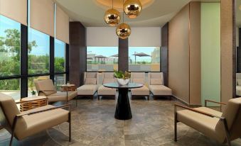 a modern , well - lit waiting area with several chairs and a dining table in the center at Radisson Blu Hotel, Bamako