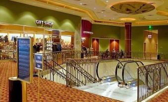 "an escalator in a large , well - lit shopping mall with a sign for a "" grand opening "" event" at Gold Country Casino Resort