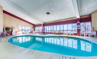 an indoor swimming pool with a view of the ocean , surrounded by lounge chairs and tables at Siegel Select Bartlett