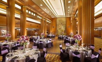 a large banquet hall filled with round tables and chairs , ready for a formal event at The Queen Mary