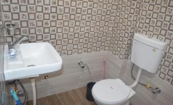 a bathroom with a toilet and sink , featuring a checkered wallpaper on the walls and wooden flooring at The Village