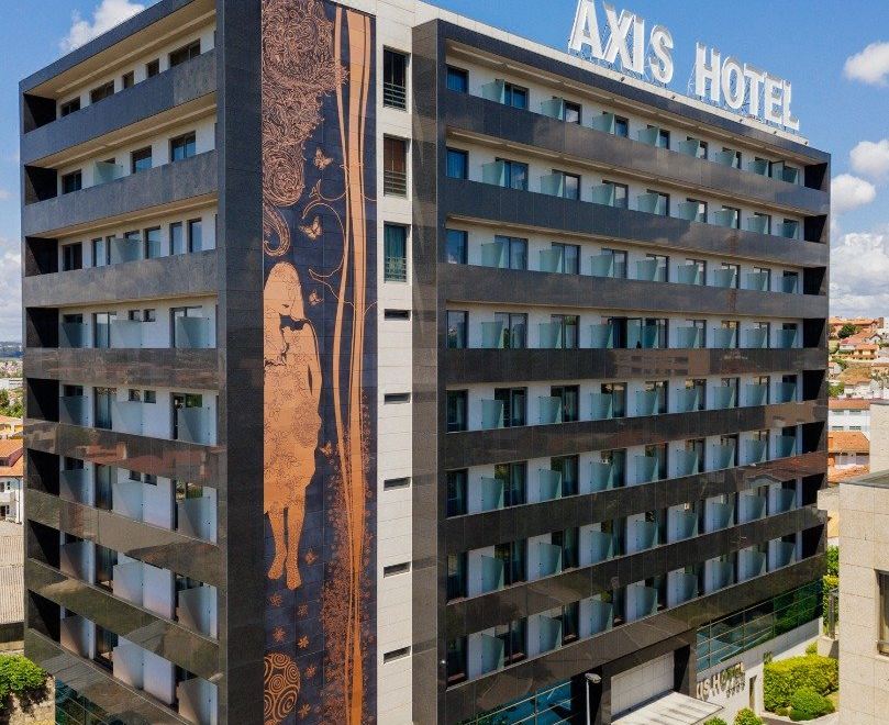 the axis hotel building is a modern , black and white hotel with a large window and an advertisement on the side at Axis Porto Business & Spa Hotel